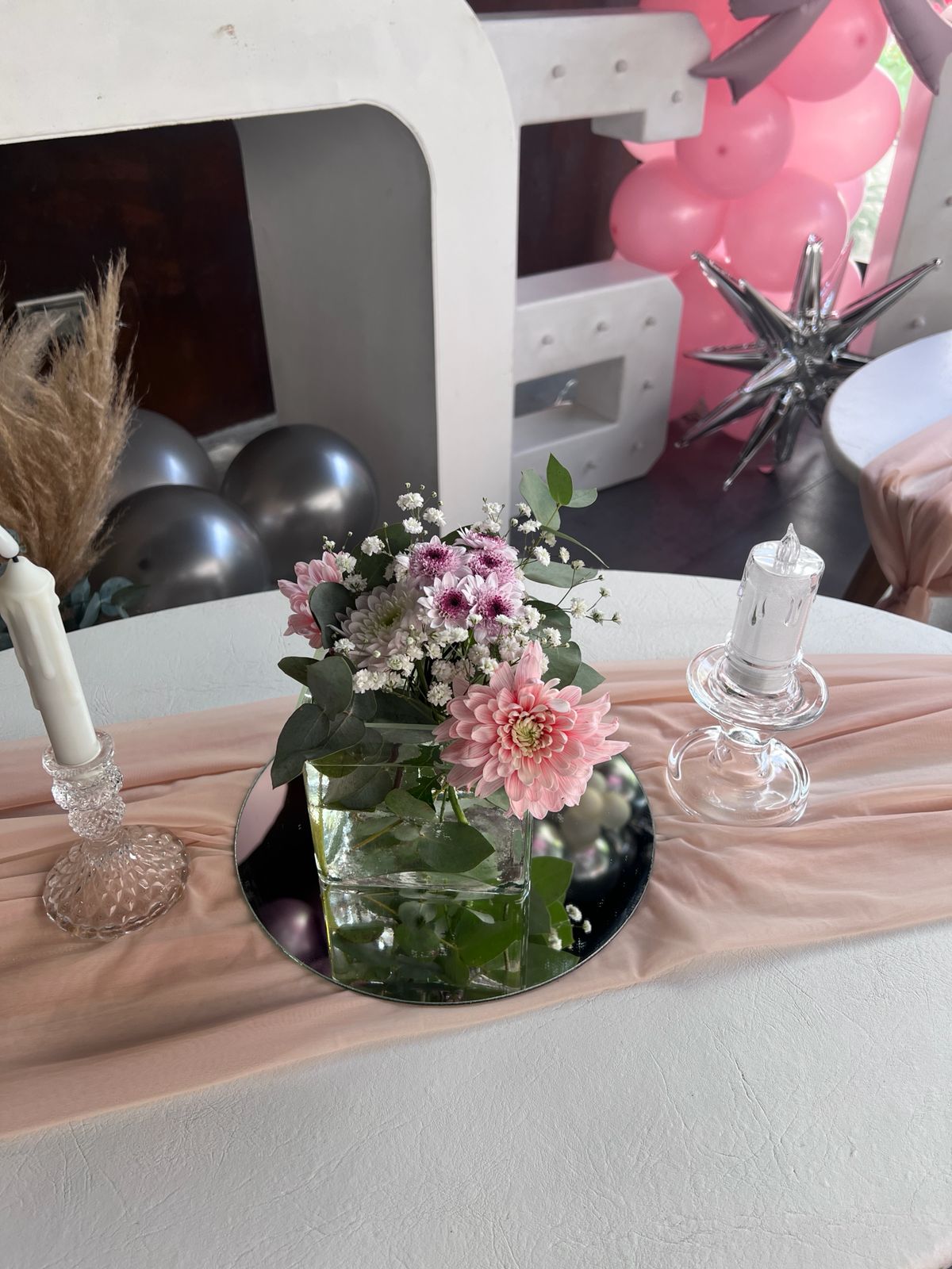 Centro de mesa con base de espejo y flores