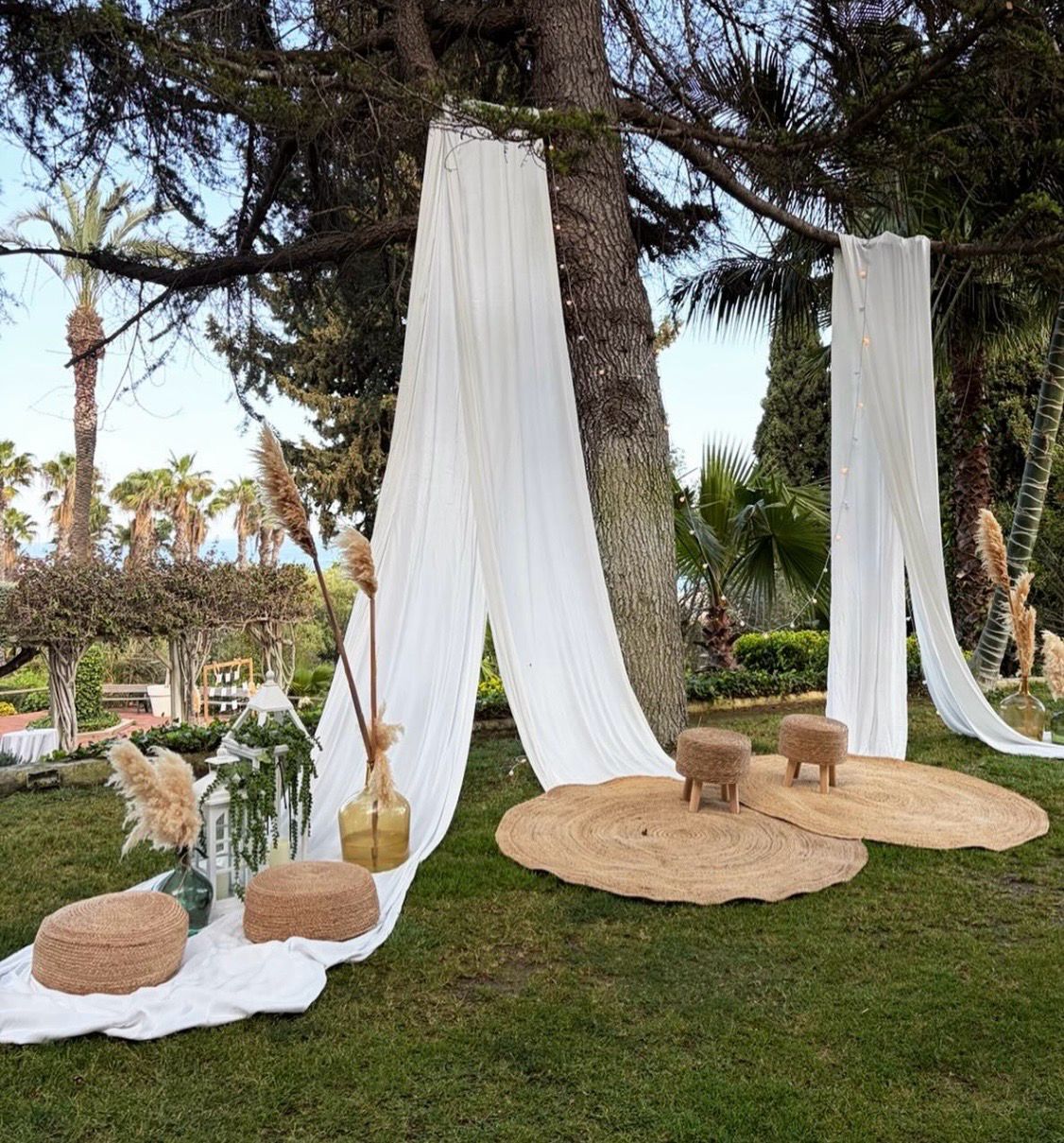 Ceremonia al aire libre con telas blancas y alfombras de yute